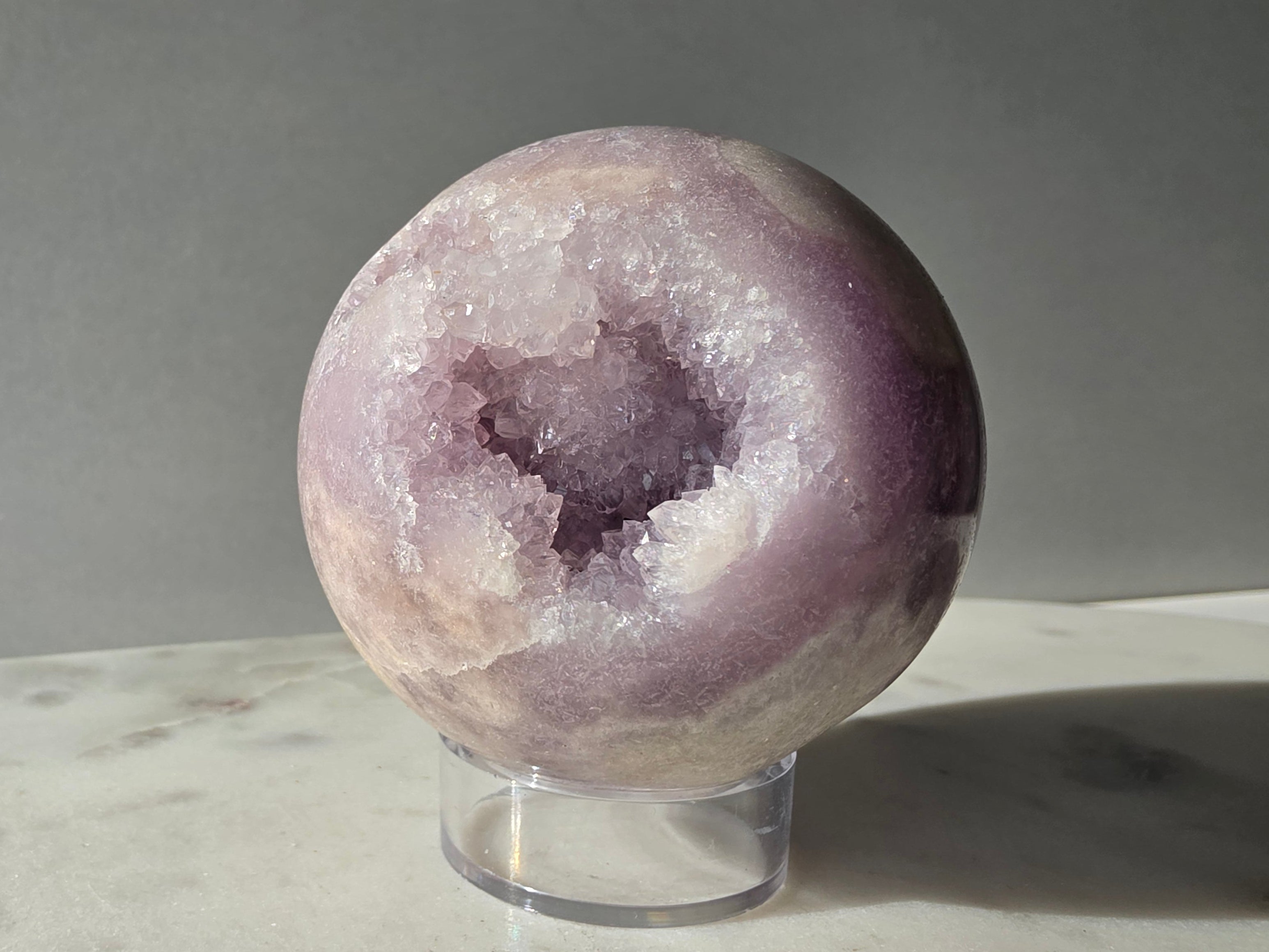 Brazilian Pink Amethyst sphere in soft lilac and lavender tones featuring a sparkling druzy cavity with a natural amethyst flower formation
