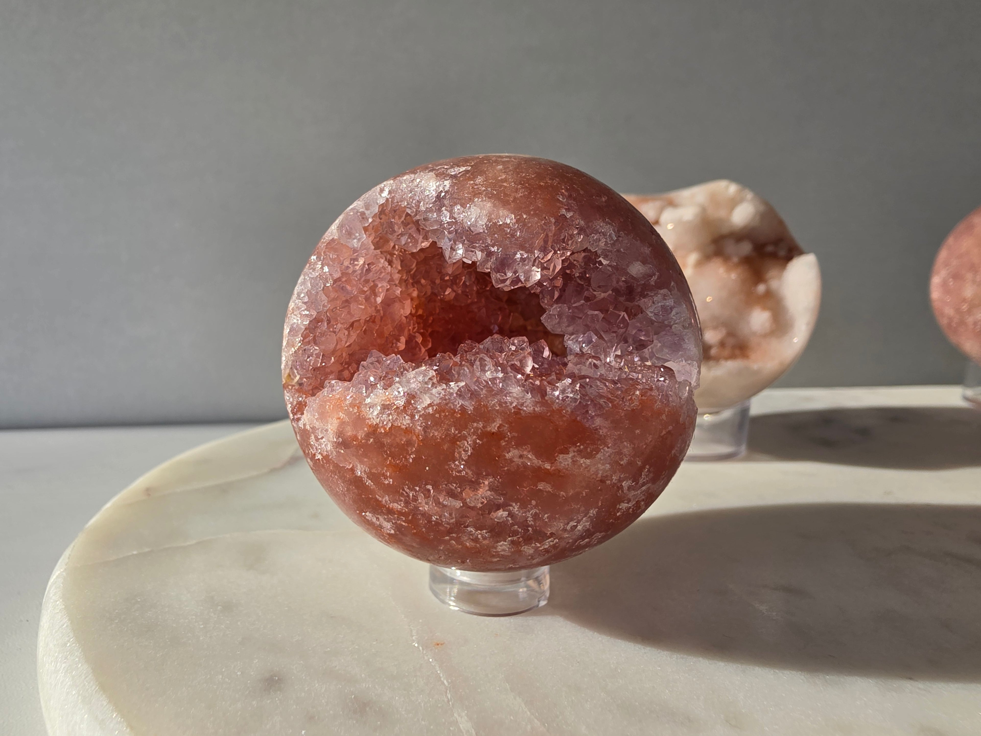 Brazilian Pink Amethyst sphere in rich blush and red-pink tones with sparkling druzy crystal formations and a natural crystalline centre, Stone & Bloom
