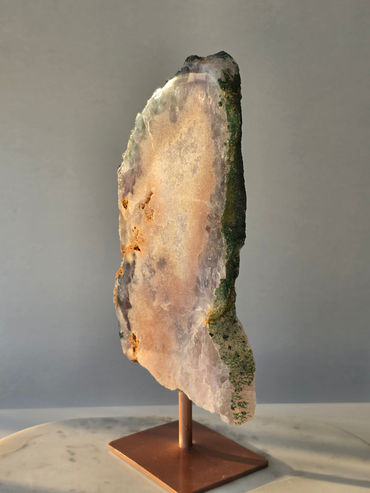 Large Brazilian Pink Amethyst slice on display stand with translucent Quartz, sparkling crystalline texture, earthy brown Jasper features and deep green natural matrix