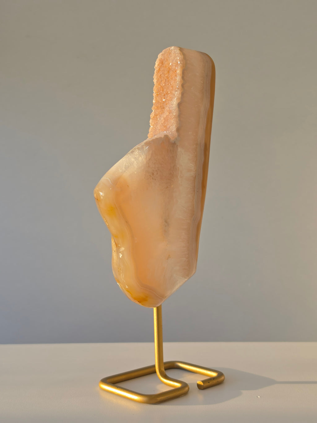 Natural Druzy Agate slab on a brushed gold stand featuring cream, champagne and caramel banding with a sparkling druzy quartz centre, luxury crystal home décor by Stone & Bloom.