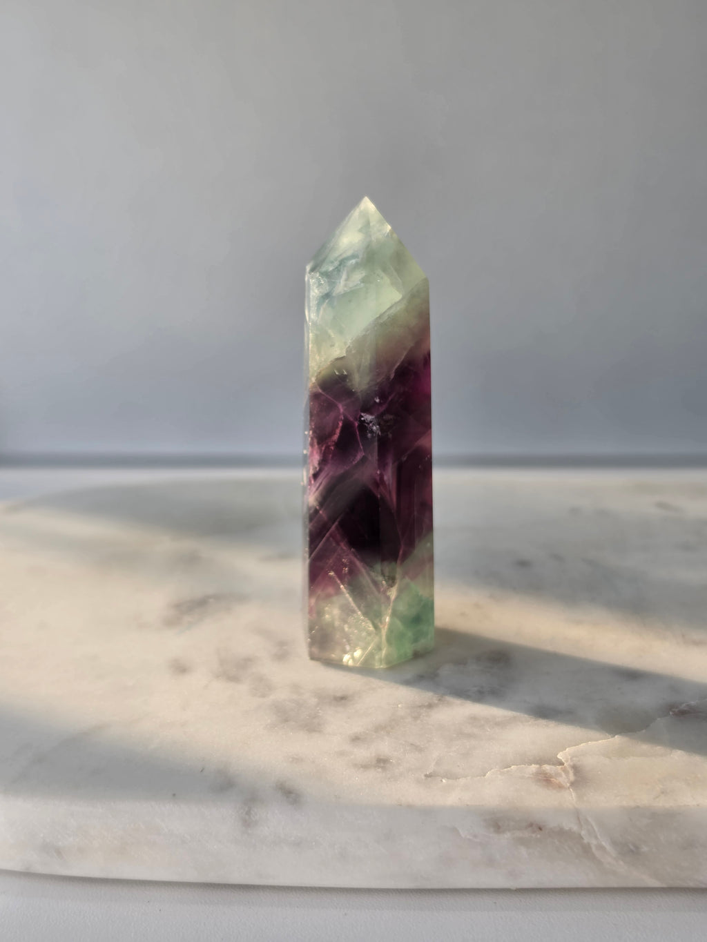 Natural Fluorite crystal point with deep purple and light green colour zoning, transparent polished finish and unique internal formations