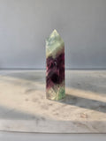 Natural Fluorite crystal point with deep purple and light green colour zoning, transparent polished finish and unique internal formations