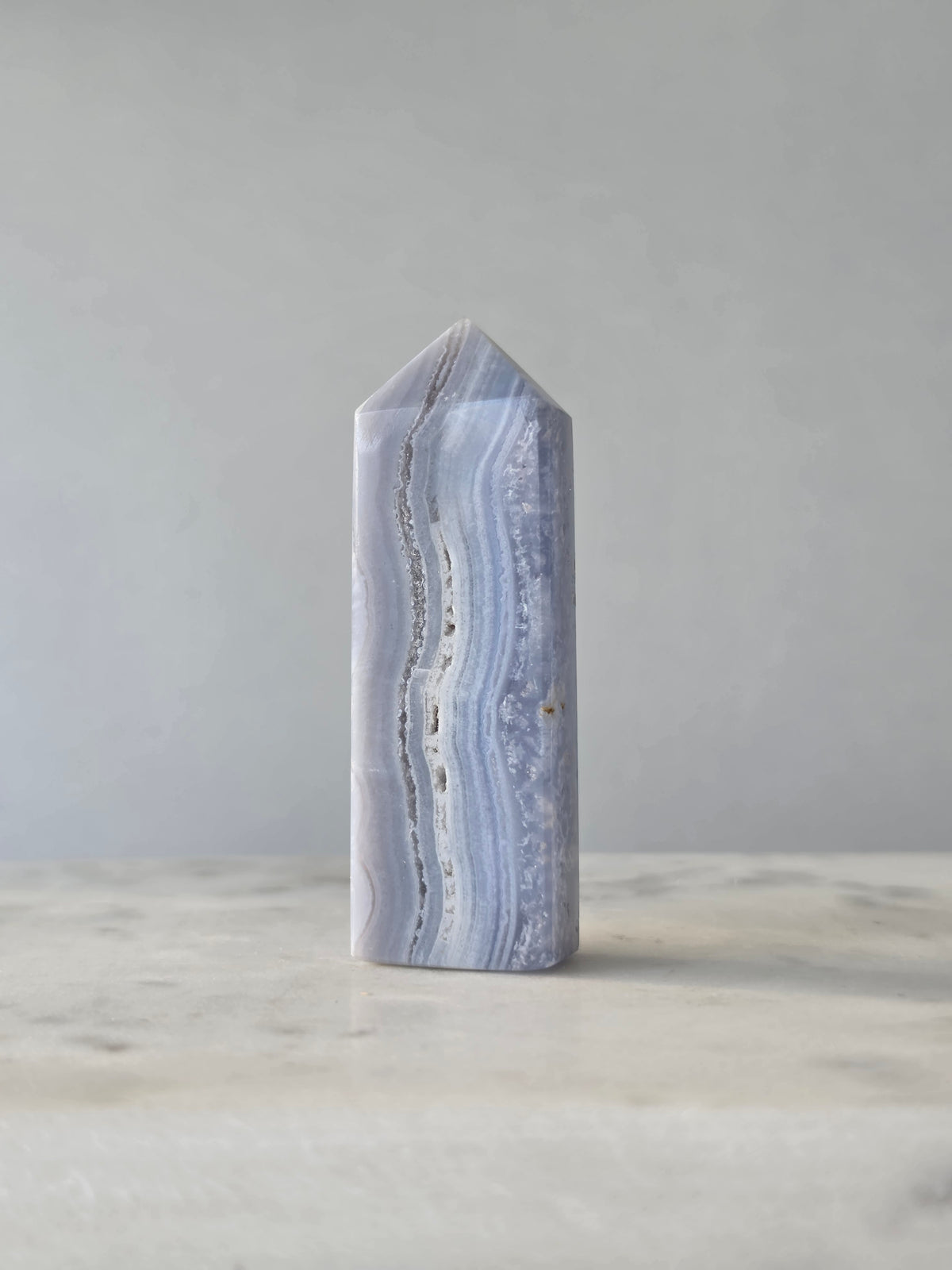 Natural Blue Lace Agate crystal point with soft blue and white banding, polished finish and unique natural formations
