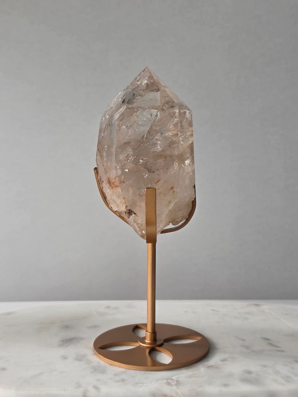 High-grade Nepalese Pink Himalayan Quartz statement piece, 606g and 19cm tall, featuring delicate pink tones, translucent crystal formations and natural inclusions, displayed on a gold stand.