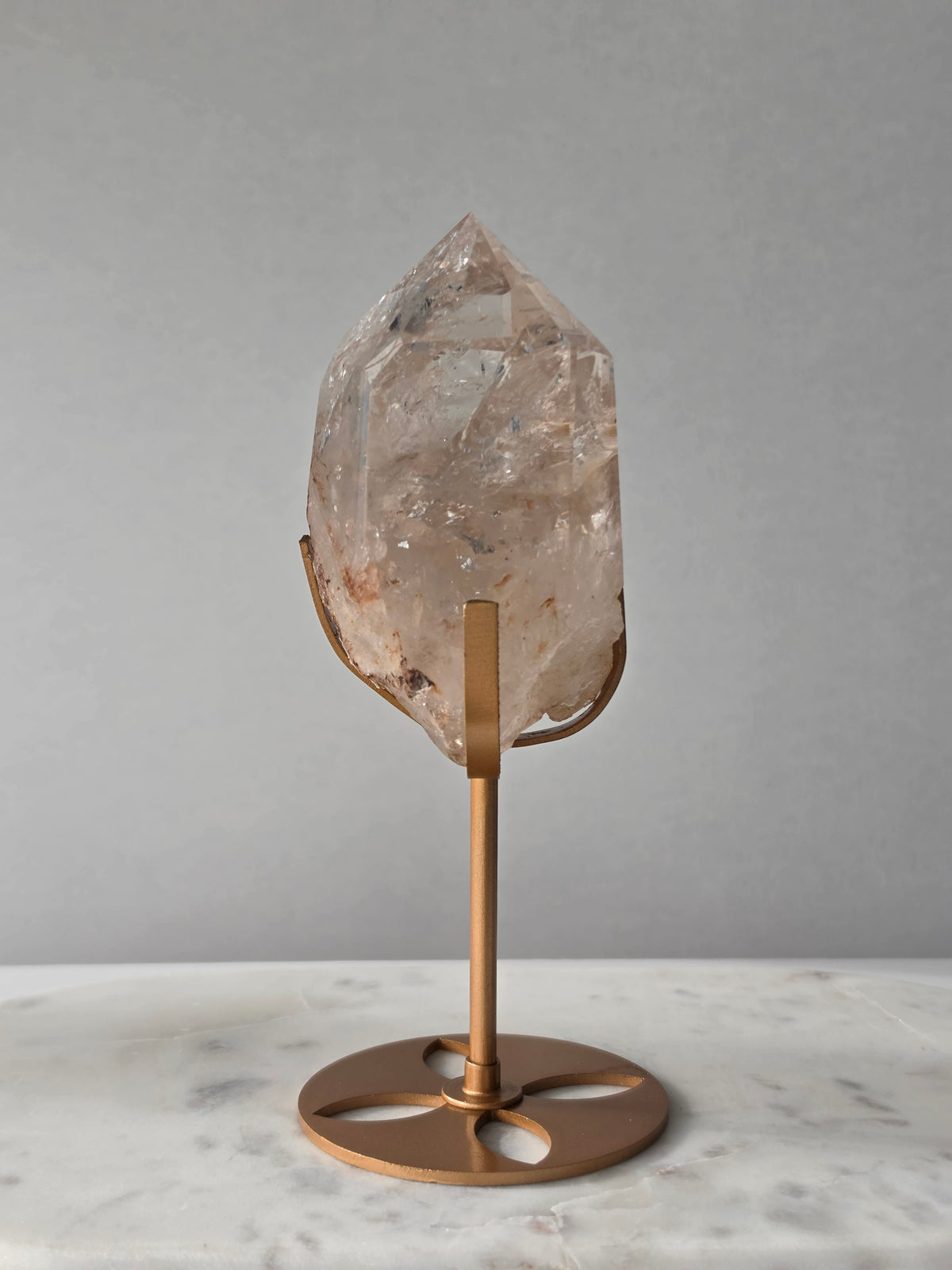 High-grade Nepalese Pink Himalayan Quartz statement piece, 606g and 19cm tall, featuring delicate pink tones, translucent crystal formations and natural inclusions, displayed on a gold stand.