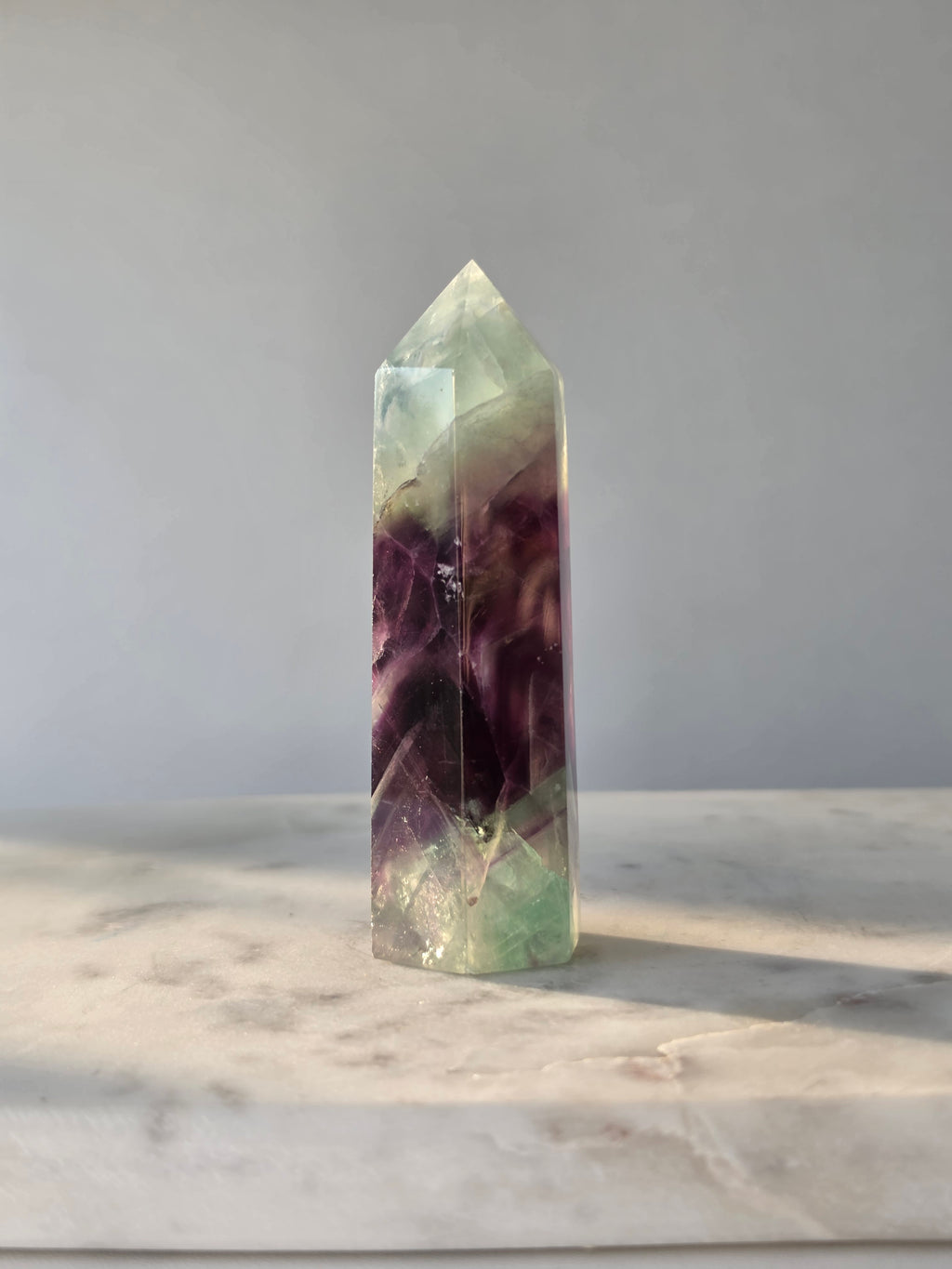 Natural Fluorite crystal point with deep purple and light green colour zoning, transparent polished finish and unique internal formations