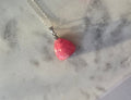 Natural Rhodochrosite teardrop pendant in 925 sterling silver with matching silver chain, featuring vibrant pink tones and unique natural patterns