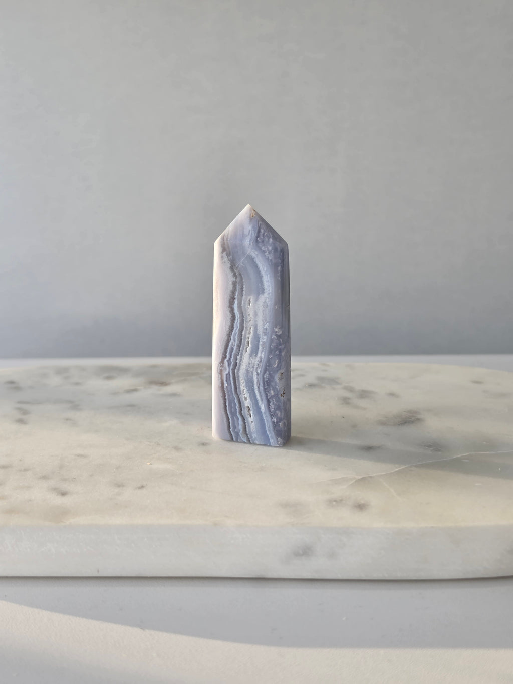 Natural Blue Lace Agate crystal point with soft blue and white banding, polished finish and unique natural formations