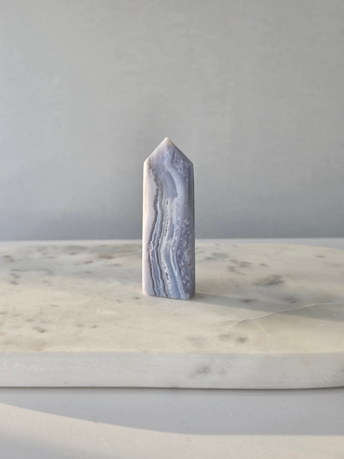 Natural Blue Lace Agate crystal point with soft blue and white banding, polished finish and unique natural formations
