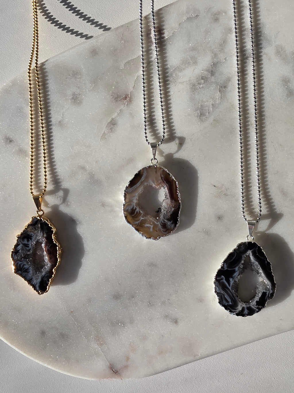 "Brazilian Agate Geode Slice Pendant in natural [brown/black/grey] tones on a silver plated chain with sparkling druzy crystal formations"