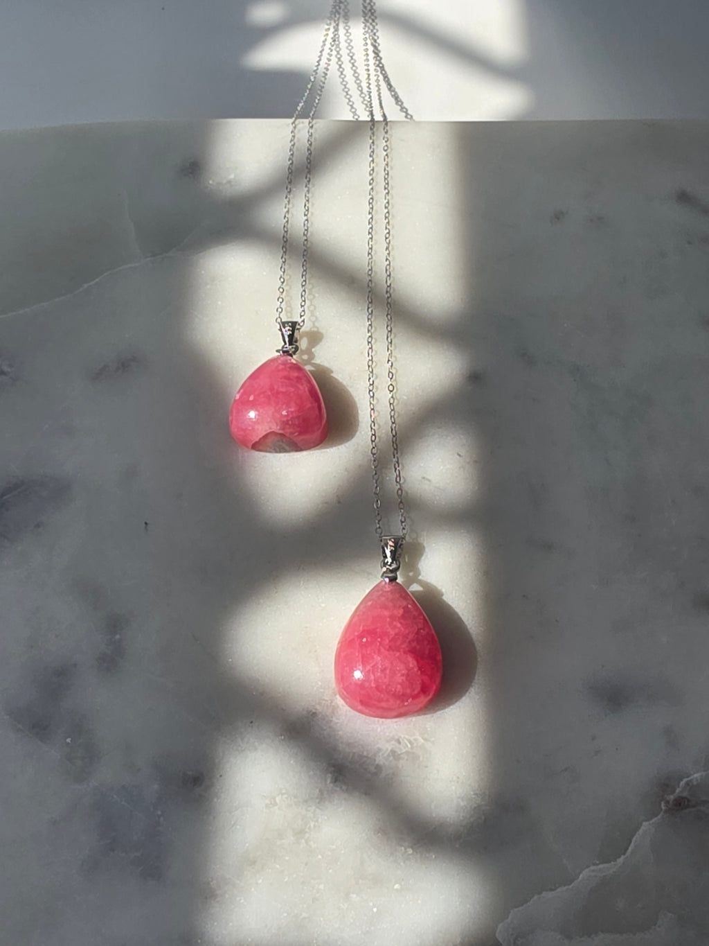 Natural Rhodochrosite teardrop pendant in 925 sterling silver with matching silver chain, featuring vibrant pink tones and unique natural patterns