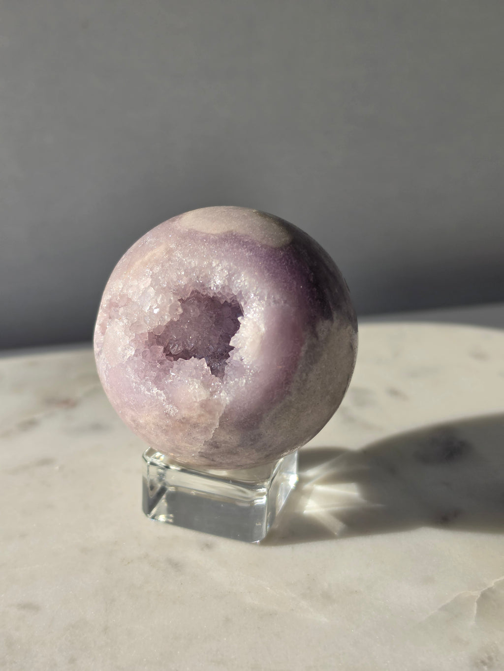 Brazilian Pink Amethyst sphere in soft lilac and lavender tones featuring a sparkling druzy cavity with a natural amethyst flower formation
