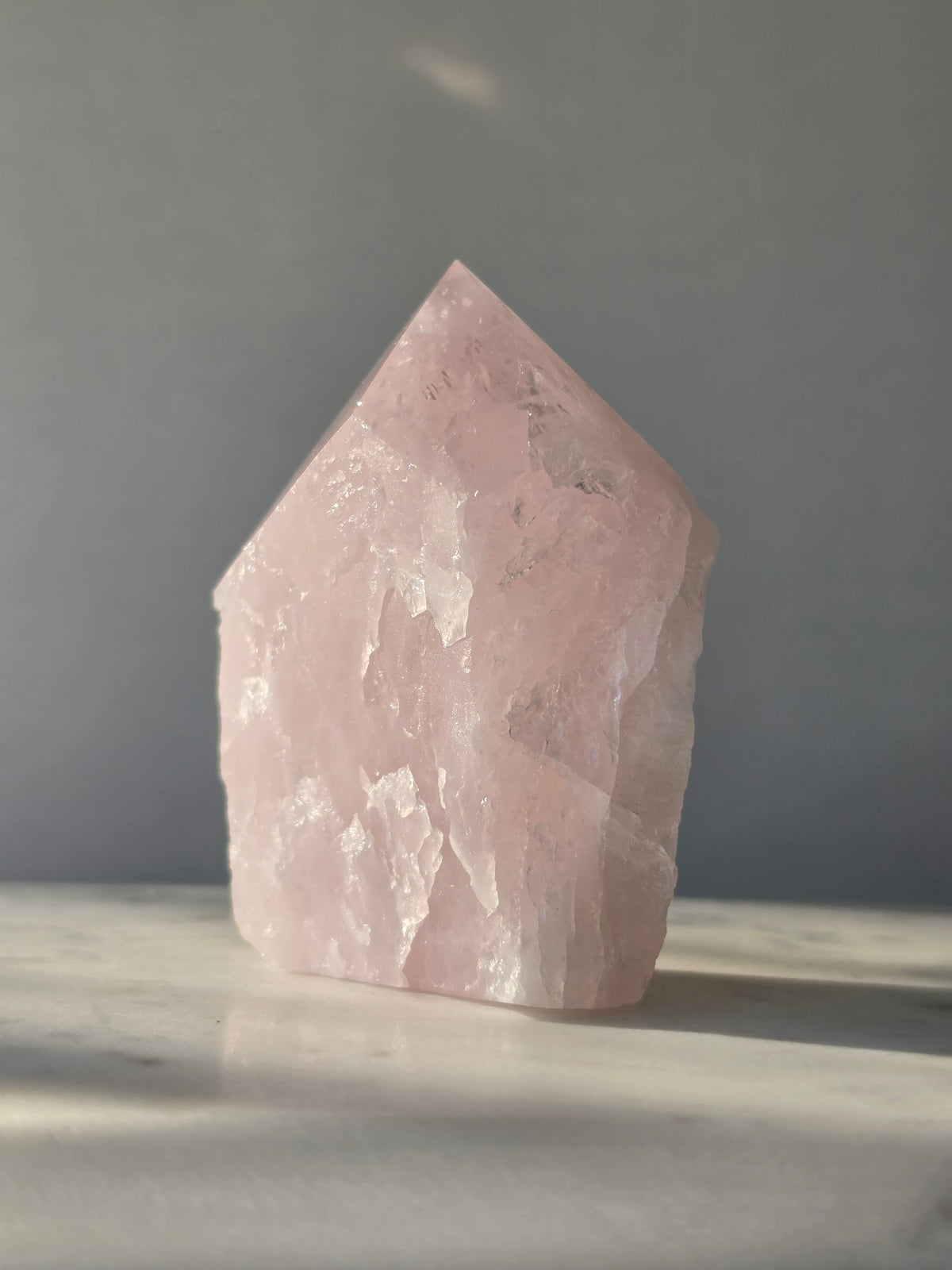 Natural Rose Quartz tower with soft blush-pink colouring, translucent areas and organic crystal formations, weighing 298g and measuring 9.5cm
