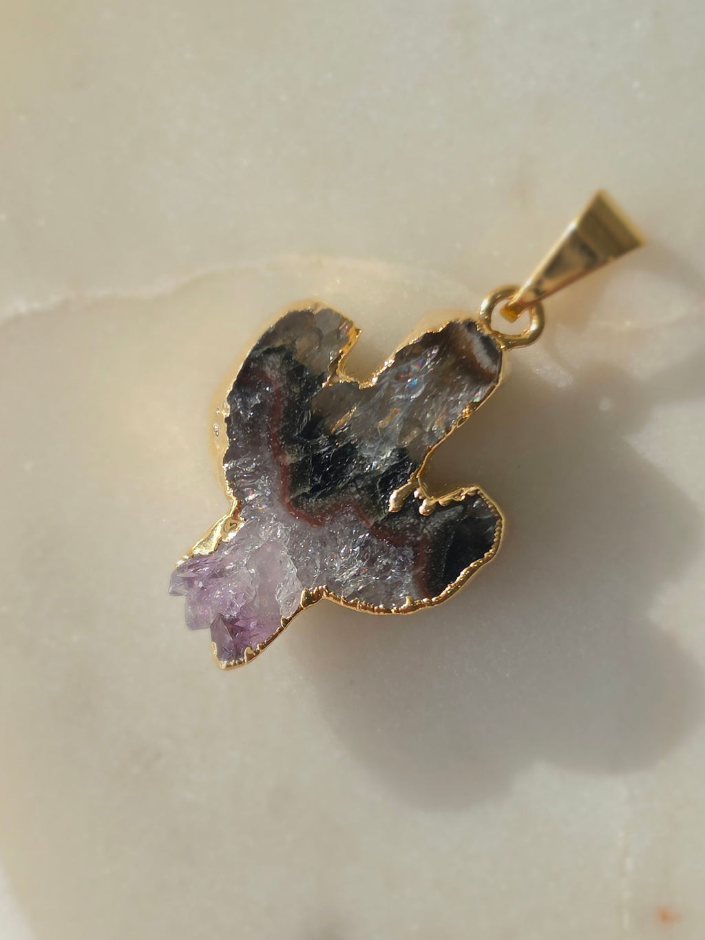 Amethyst and agate cactus slice pendant featuring deep translucent smoky-grey agate, red banding and purple crystal formations and a 24K gold-plated outline.