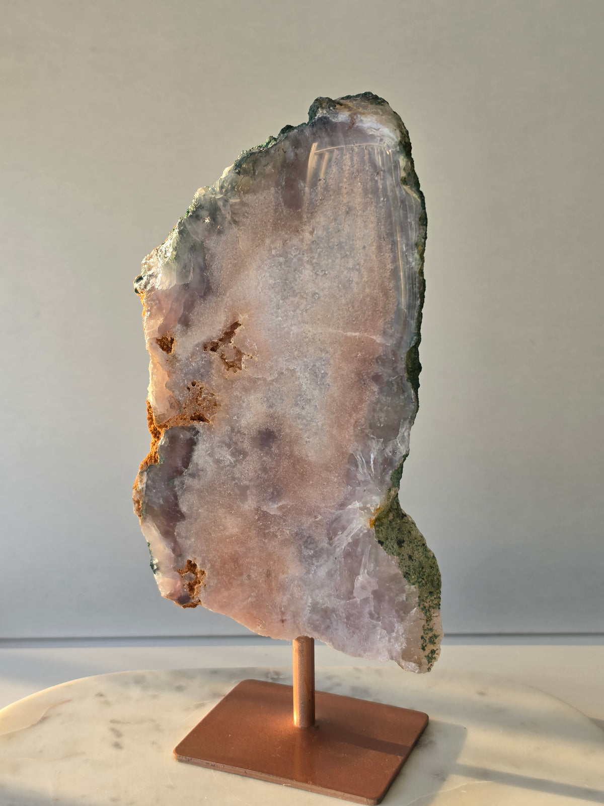 Large Brazilian Pink Amethyst slice on display stand with translucent Quartz, sparkling crystalline texture, earthy brown Jasper features and deep green natural matrix