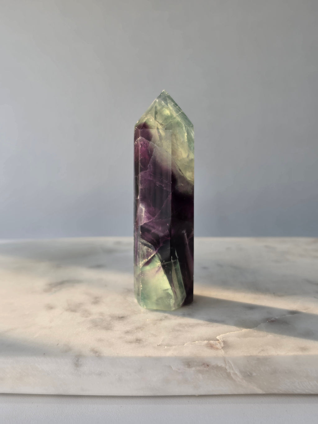 Natural Fluorite crystal point with deep purple and light green colour zoning, transparent polished finish and unique internal formations