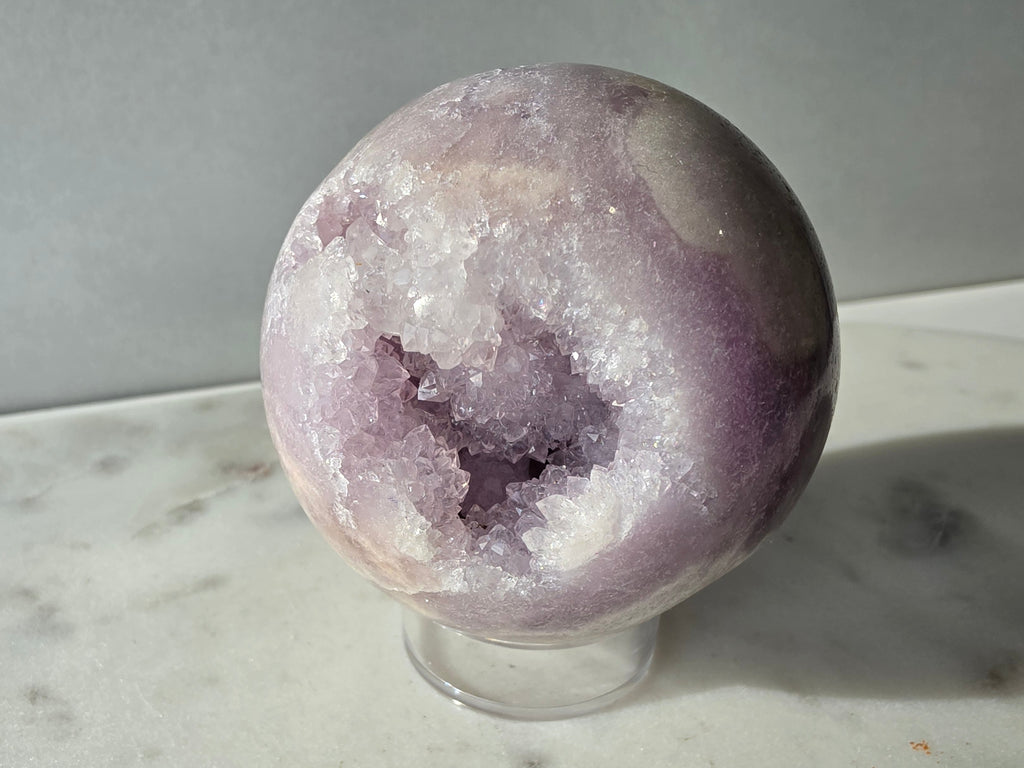 Brazilian Pink Amethyst sphere in soft lilac and lavender tones featuring a sparkling druzy cavity with a natural amethyst flower formation