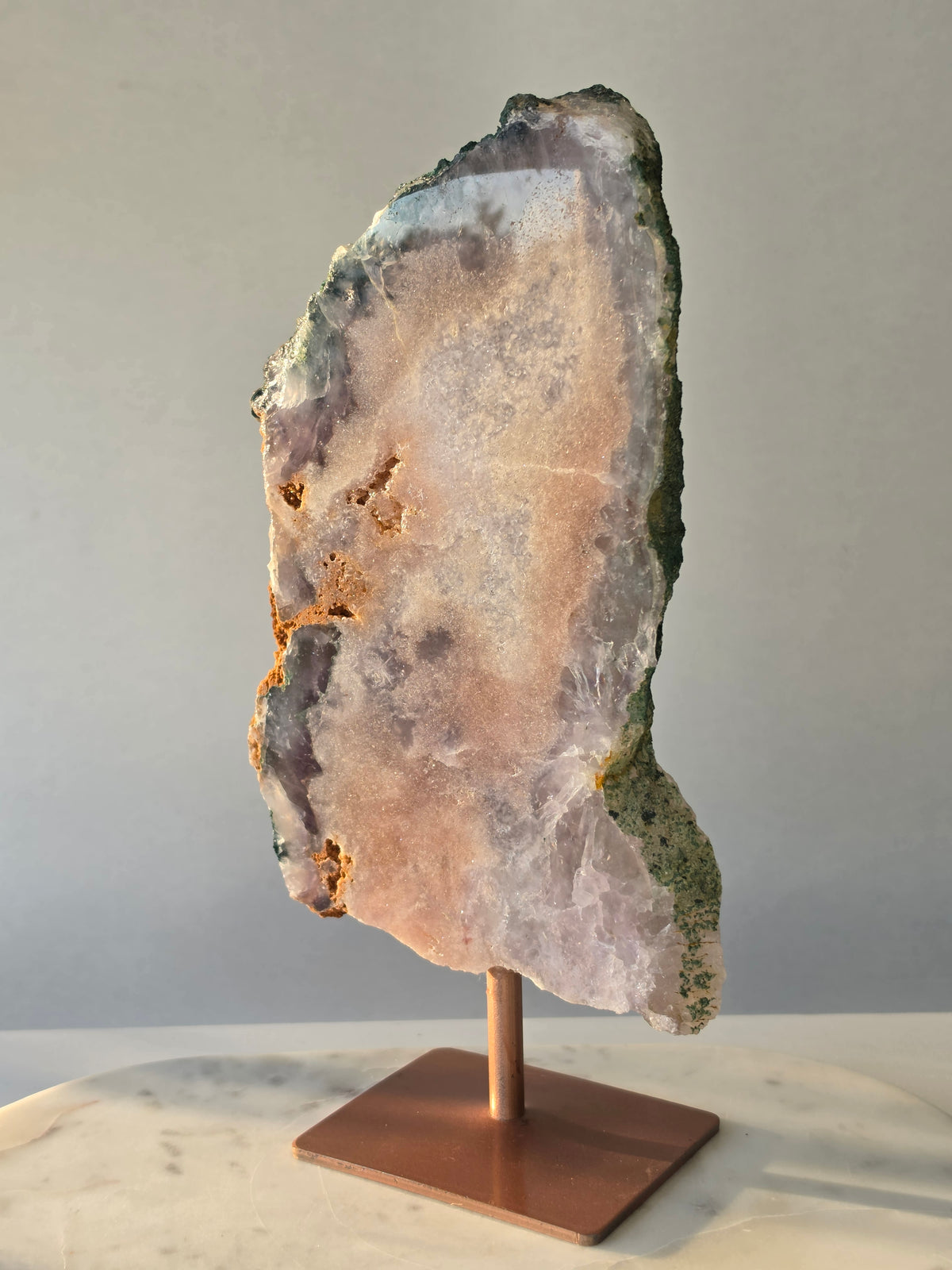 Large Brazilian Pink Amethyst slice on display stand with translucent Quartz, sparkling crystalline texture, earthy brown Jasper features and deep green natural matrix