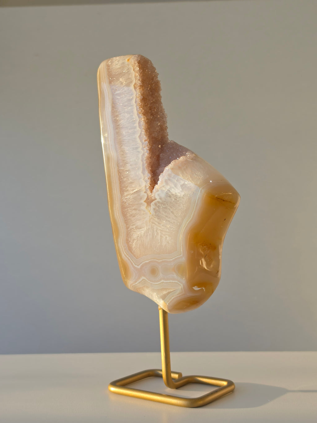 Natural Druzy Agate slab on a brushed gold stand featuring cream, champagne and caramel banding with a sparkling druzy quartz centre, luxury crystal home décor by Stone & Bloom.